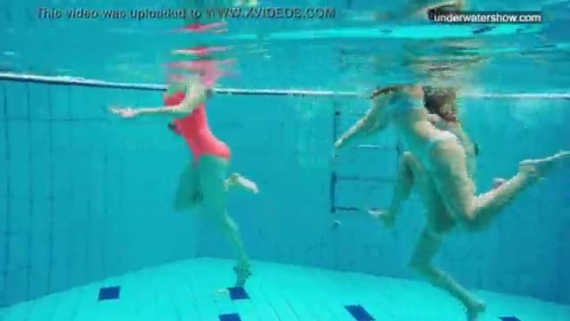 Three nude girls have fun underwater
